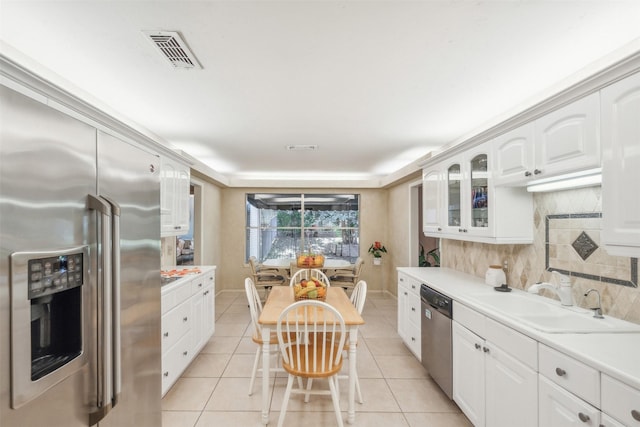 6 Crosslands Rd, Benbrook, TX 76132 - kitchen with stainless steel appliances, a sink, light countertops, decorative backsplash, and white cabinetry