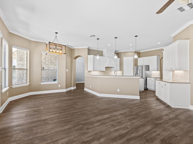 1105 Crown Valley Dr, Weatherford, TX 76087 - kitchen with arched walkways, stainless steel fridge with ice dispenser, ceiling fan, decorative backsplash, and crown molding