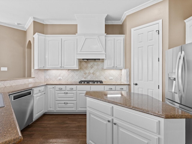 1105 Crown Valley Dr, Weatherford, TX 76087 - kitchen with appliances with stainless steel finishes, ornamental molding, dark stone counters, backsplash, and white cabinetry
