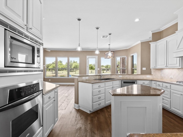 1105 Crown Valley Dr, Weatherford, TX 76087 - kitchen with stainless steel appliances, a sink, crown molding, a peninsula, and backsplash