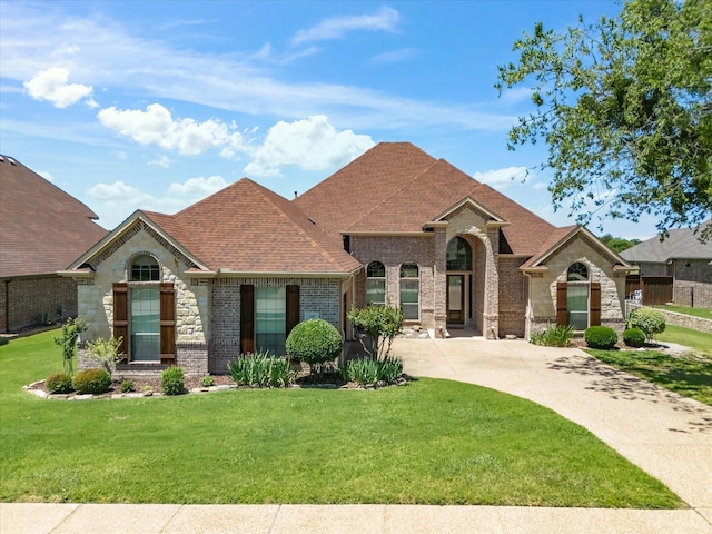 1105 Crown Valley Dr, Weatherford, TX 76087 - french country inspired facade featuring a front lawn, brick siding, roof with shingles, and stone siding