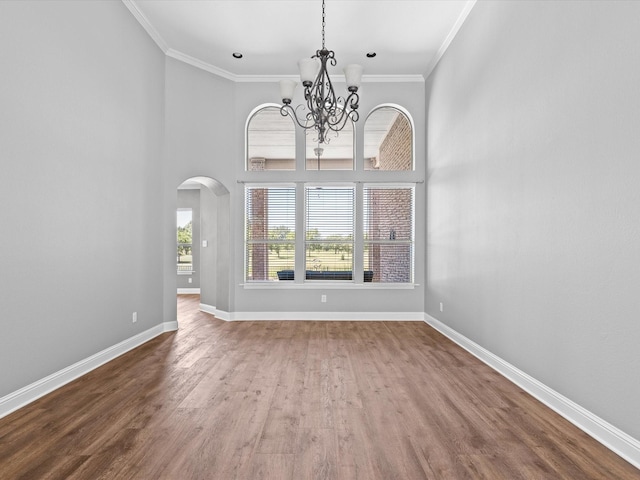 1105 Crown Valley Dr, Weatherford, TX 76087 - unfurnished dining area featuring a chandelier, arched walkways, baseboards, crown molding, and wood finished floors