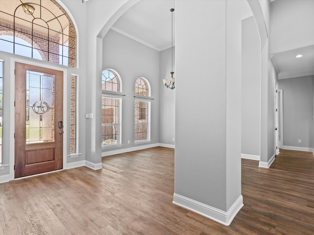 1105 Crown Valley Dr, Weatherford, TX 76087 - foyer entrance featuring a towering ceiling, crown molding, wood finished floors, baseboards, and arched walkways