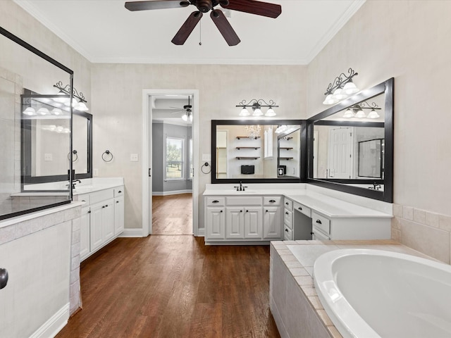 1105 Crown Valley Dr, Weatherford, TX 76087 - bathroom with ceiling fan, a bath, wood finished floors, two vanities, and crown molding