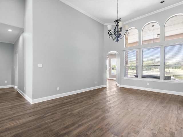 1105 Crown Valley Dr, Weatherford, TX 76087 - unfurnished living room featuring ornamental molding, baseboards, arched walkways, dark wood-type flooring, and a chandelier