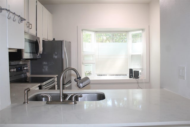 2807 Throckmorton St Unit 101, Dallas, TX 75219 - kitchen featuring stainless steel appliances, a sink, white cabinetry, and tasteful backsplash