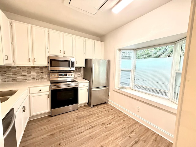 2807 Throckmorton St Unit 101, Dallas, TX 75219 - kitchen featuring appliances with stainless steel finishes, tasteful backsplash, white cabinetry, light wood-type flooring, and light countertops