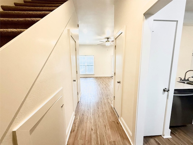 2807 Throckmorton St Unit 101, Dallas, TX 75219 - hallway with light wood finished floors, a sink, and baseboards