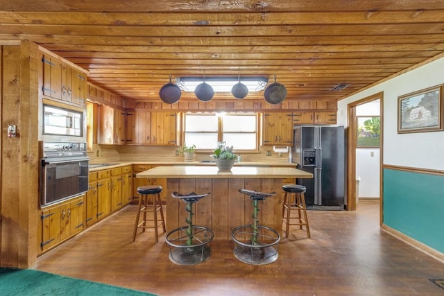 13220 Briar Rd, Azle, TX 76020 - kitchen featuring black appliances, wood ceiling, light countertops, wood finished floors, and a center island