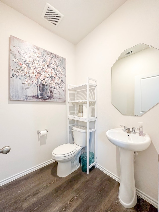 3225 Conley Ct, Mesquite, TX 75126 - half bathroom featuring wood finished floors, baseboards, toilet, and a sink