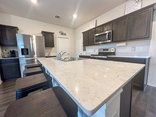 3225 Conley Ct, Mesquite, TX 75126 - kitchen featuring stainless steel appliances, a sink, dark wood-style floors, dark brown cabinetry, and a kitchen island with sink