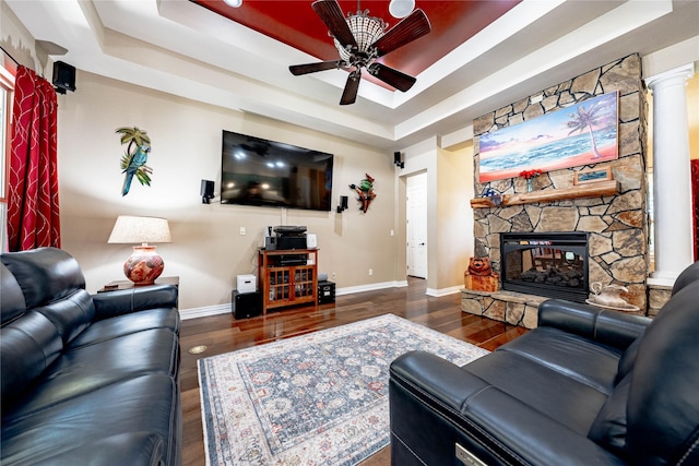 6296 Fm 1256, Mabank, TX 75147 - living area featuring a raised ceiling, ceiling fan, wood finished floors, a stone fireplace, and baseboards