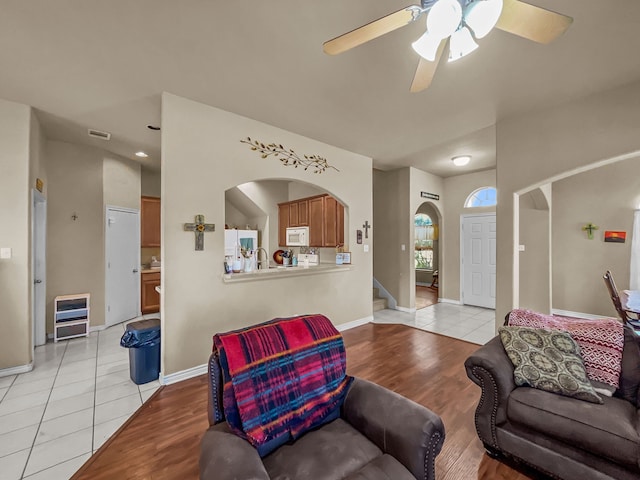 301 Quail Run Rd, Red Oak, TX 75154 - living area with arched walkways, ceiling fan, light wood-style floors, baseboards, and stairs