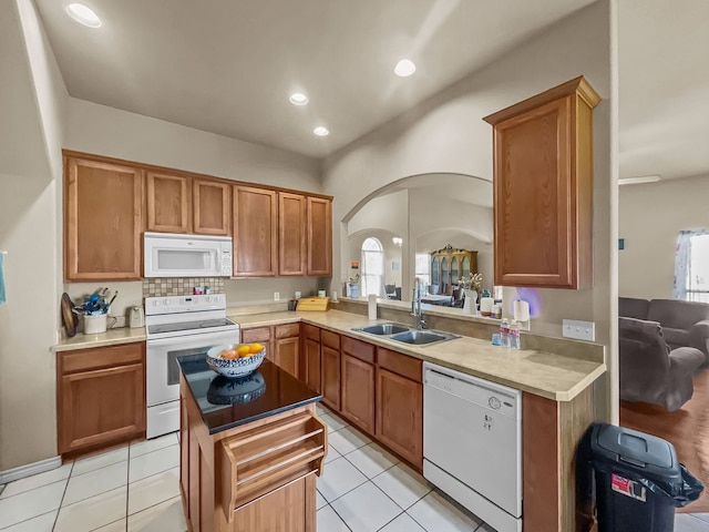 301 Quail Run Rd, Red Oak, TX 75154 - kitchen with white appliances, a sink, arched walkways, brown cabinets, and light countertops