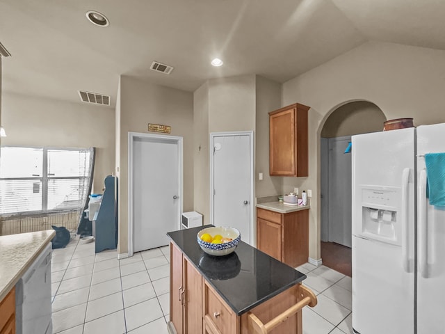 301 Quail Run Rd, Red Oak, TX 75154 - kitchen with white fridge with ice dispenser, light tile patterned floors, brown cabinetry, a kitchen island, and dishwasher
