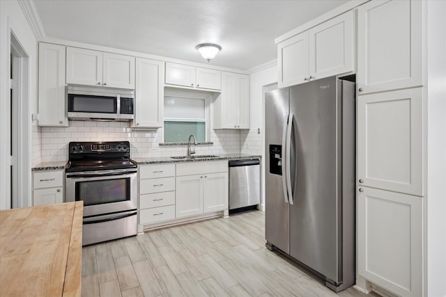 5409 Queens Ct, Lake Dallas, TX 75065 - kitchen with appliances with stainless steel finishes, a sink, butcher block counters, backsplash, and white cabinetry