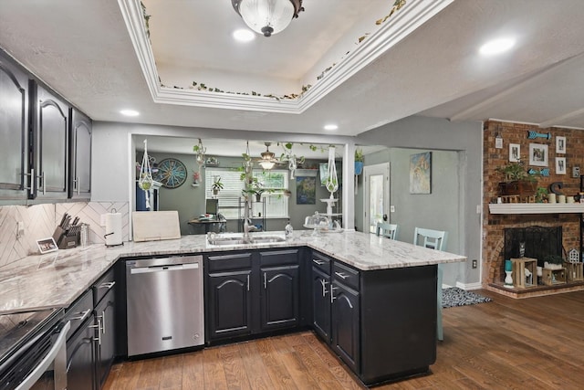 7028 Whitewood Dr, Fort Worth, TX 76137 - kitchen featuring stainless steel appliances, light stone counters, a peninsula, a sink, and wood finished floors