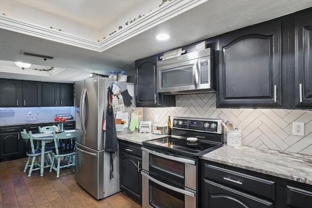 7028 Whitewood Dr, Fort Worth, TX 76137 - kitchen featuring appliances with stainless steel finishes, decorative backsplash, dark wood-style flooring, and light stone counters