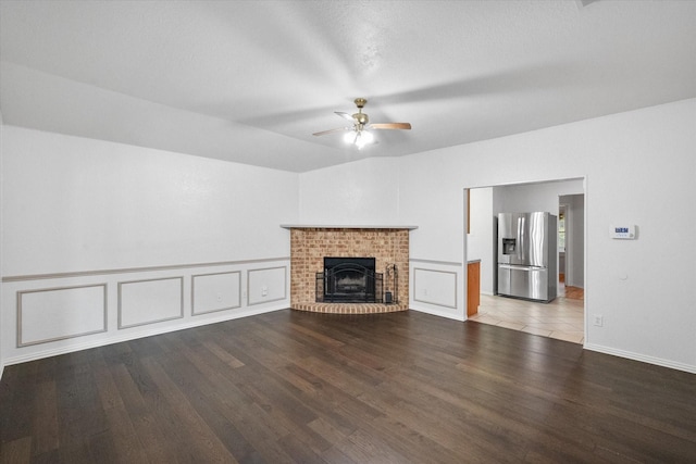 415 Blueberry Hill Ln, Mansfield, TX 76063 - unfurnished living room featuring a ceiling fan, wood finished floors, a fireplace, and a decorative wall