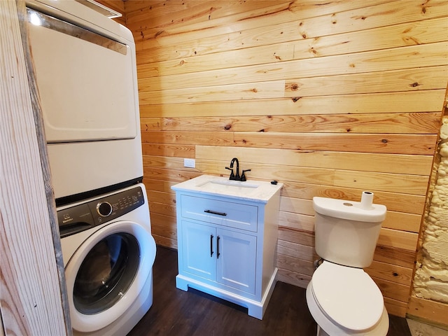 291 County Road 4833, Leonard, TX 75452 - laundry room with stacked washer / drying machine, wooden walls, and dark wood-style flooring