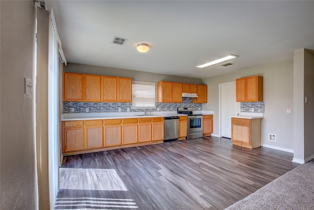 1057 Castle Top Dr, Fort Worth, TX 76052 - kitchen with appliances with stainless steel finishes, a sink, decorative backsplash, dark wood-type flooring, and light countertops