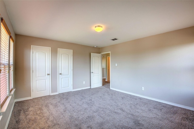 1057 Castle Top Dr, Fort Worth, TX 76052 - unfurnished bedroom featuring carpet flooring, baseboards, and two closets