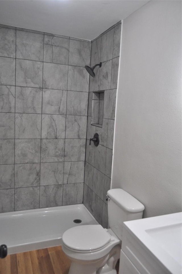 722 Sunset St, Sulphur Springs, TX 75482 - bathroom featuring tiled shower, toilet, wood finished floors, and vanity
