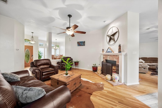 8405 Circleview St, Rowlett, TX 75088 - living area with a ceiling fan, light wood finished floors, a brick fireplace, baseboards, and a chandelier