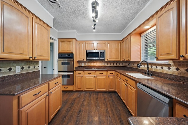 2009 Botts Dr, Arlington, TX 76012 - kitchen featuring stainless steel appliances, a sink, tasteful backsplash, dark wood-type flooring, and a textured ceiling
