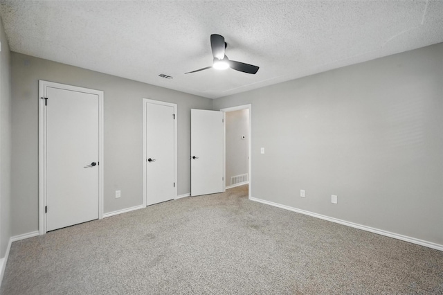 2009 Botts Dr, Arlington, TX 76012 - unfurnished bedroom featuring a textured ceiling, carpet floors, baseboards, two closets, and ceiling fan