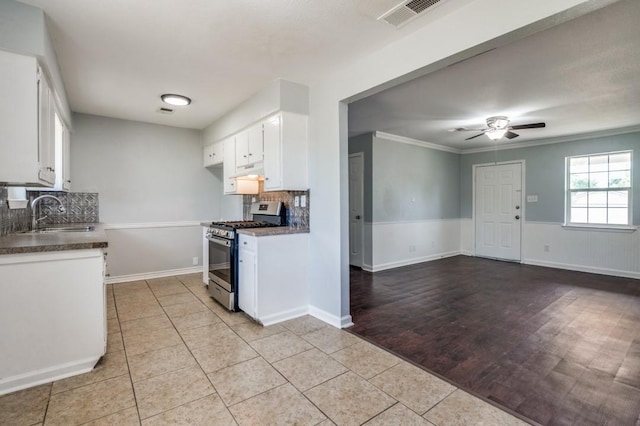 204 E Willow Ln, Princeton, TX 75407 - kitchen featuring stainless steel range with gas stovetop, a sink, a ceiling fan, white cabinetry, and tasteful backsplash