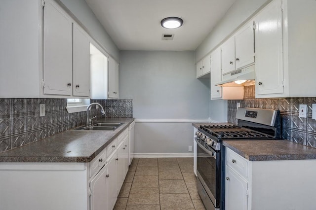 204 E Willow Ln, Princeton, TX 75407 - kitchen with gas range, under cabinet range hood, a sink, dark countertops, and white cabinets