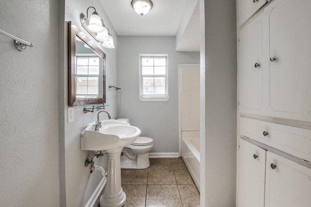 204 E Willow Ln, Princeton, TX 75407 - bathroom featuring toilet, tile patterned floors, baseboards, and a sink