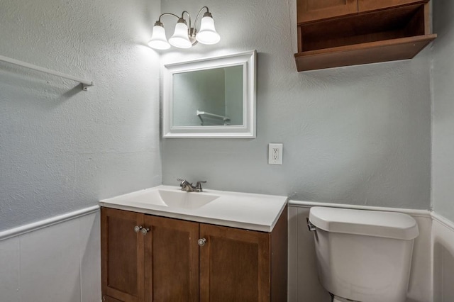 204 E Willow Ln, Princeton, TX 75407 - half bathroom with vanity, a wainscoted wall, and toilet