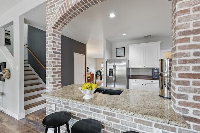 3964 Hunter Peak Rd, Fort Worth, TX 76262 - kitchen with stainless steel fridge, a sink, white cabinetry, light stone counters, and dark wood-type flooring