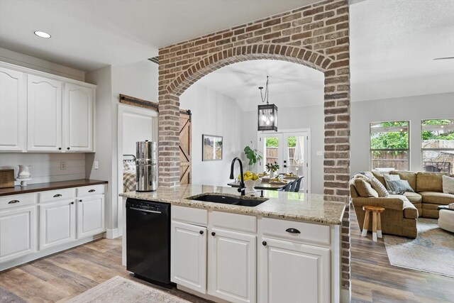 3964 Hunter Peak Rd, Fort Worth, TX 76262 - kitchen with black dishwasher, a sink, light wood-style flooring, arched walkways, and recessed lighting
