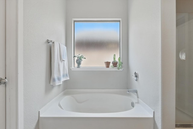 3964 Hunter Peak Rd, Fort Worth, TX 76262 - bathroom with a textured wall, a bath, and a shower