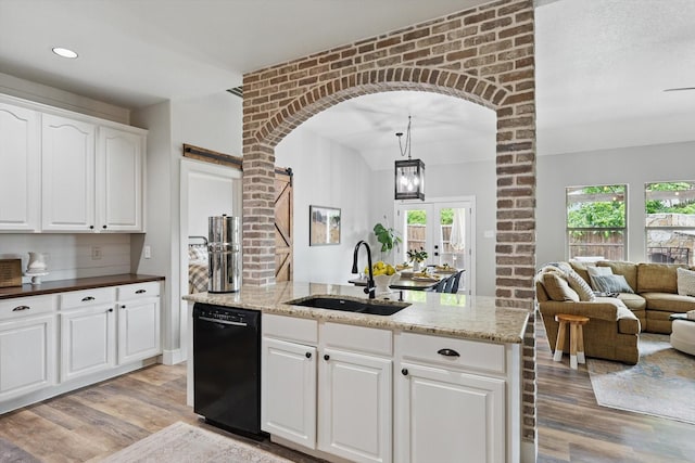 3964 Hunter Peak Rd, Fort Worth, TX 76262 - kitchen with black dishwasher, a sink, light wood-style floors, arched walkways, and recessed lighting