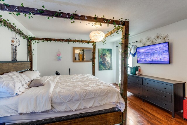 5816 Birchbrook Dr Unit 118, Dallas, TX 75206 - bedroom featuring wood finished floors and a chandelier