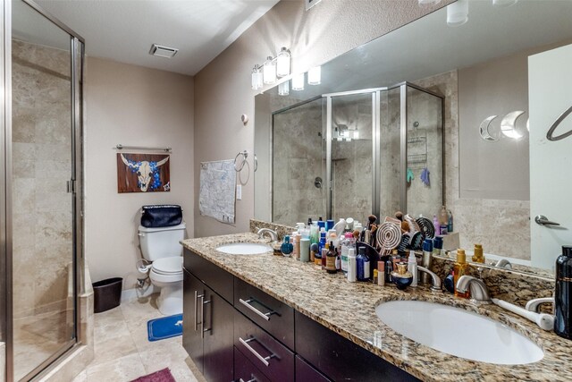 5816 Birchbrook Dr Unit 118, Dallas, TX 75206 - full bathroom featuring double vanity, a shower stall, toilet, and tile patterned floors