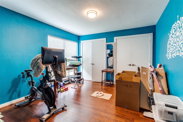 5816 Birchbrook Dr Unit 118, Dallas, TX 75206 - exercise area with wood finished floors and a textured ceiling