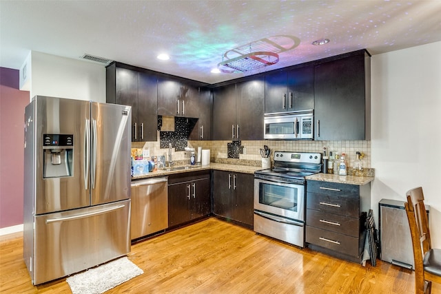 5816 Birchbrook Dr Unit 118, Dallas, TX 75206 - kitchen featuring stainless steel appliances, a sink, light wood-style flooring, backsplash, and recessed lighting