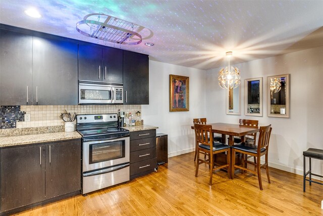 5816 Birchbrook Dr Unit 118, Dallas, TX 75206 - kitchen featuring stainless steel appliances, baseboards, light wood-type flooring, and decorative backsplash