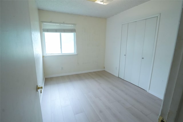 706 Midway Dr W, Euless, TX 76039 - unfurnished bedroom featuring light wood-style floors, a closet, and baseboards