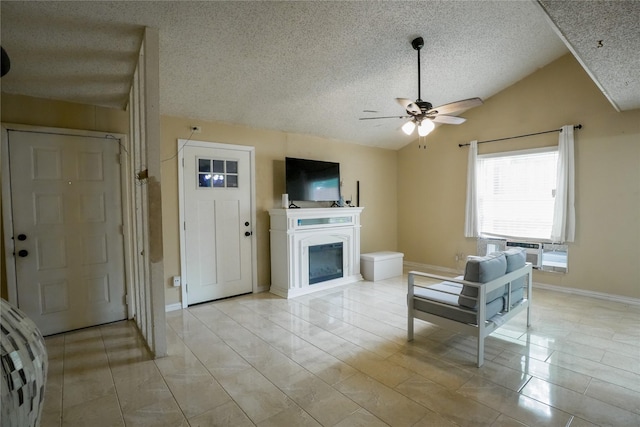 706 Midway Dr W, Euless, TX 76039 - living room featuring vaulted ceiling, a textured ceiling, a ceiling fan, a glass covered fireplace, and baseboards