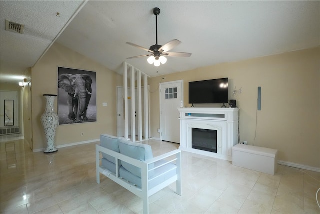 706 Midway Dr W, Euless, TX 76039 - tiled living area featuring a ceiling fan, lofted ceiling, a glass covered fireplace, and baseboards