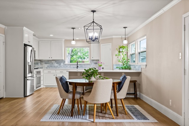 3455 Timberview Rd, Dallas, TX 75229 - dining space with light wood-style floors, a chandelier, baseboards, and crown molding
