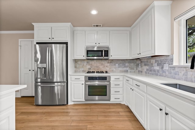 3455 Timberview Rd, Dallas, TX 75229 - kitchen with appliances with stainless steel finishes, white cabinets, light countertops, tasteful backsplash, and crown molding