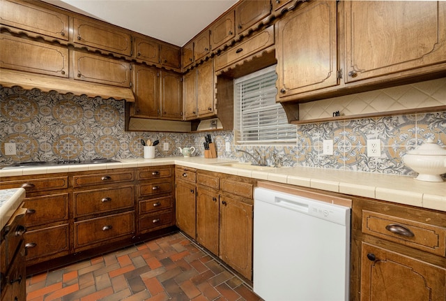 3410 Ellis Ave, Fort Worth, TX 76106 - kitchen with dishwasher, backsplash, gas stovetop, brick flooring, and brown cabinetry