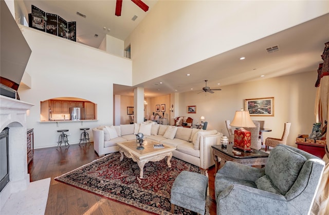 2132 Portofino Dr, Rockwall, TX 75032 - living area featuring ceiling fan, a glass covered fireplace, dark wood-style flooring, recessed lighting, and a towering ceiling